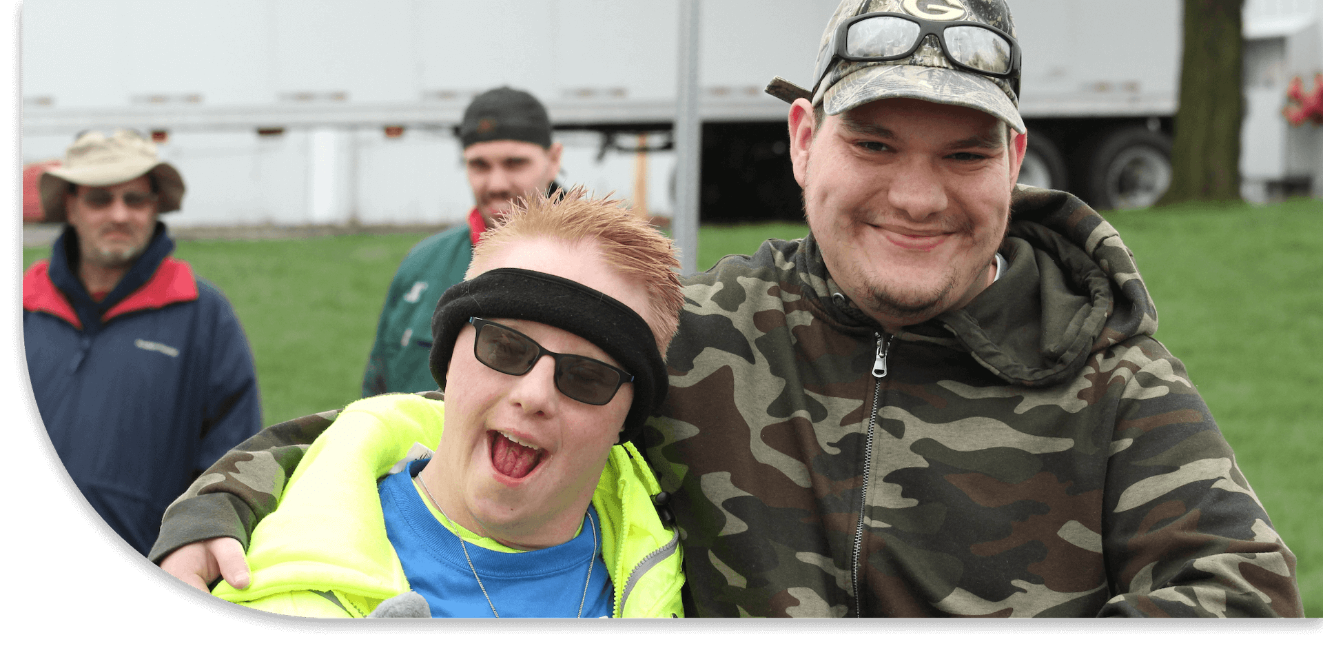 Friends smiling standing with arms around each other.