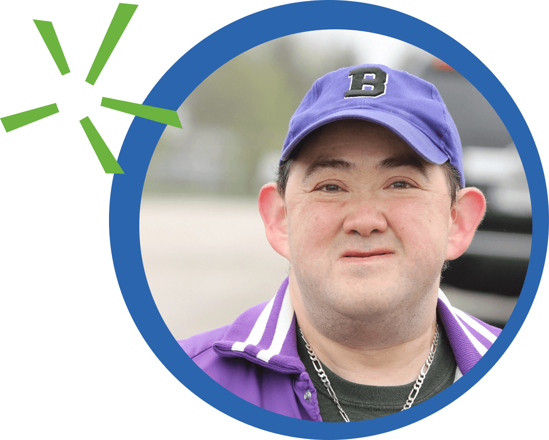 Man Smiling with purple hat and track jacket