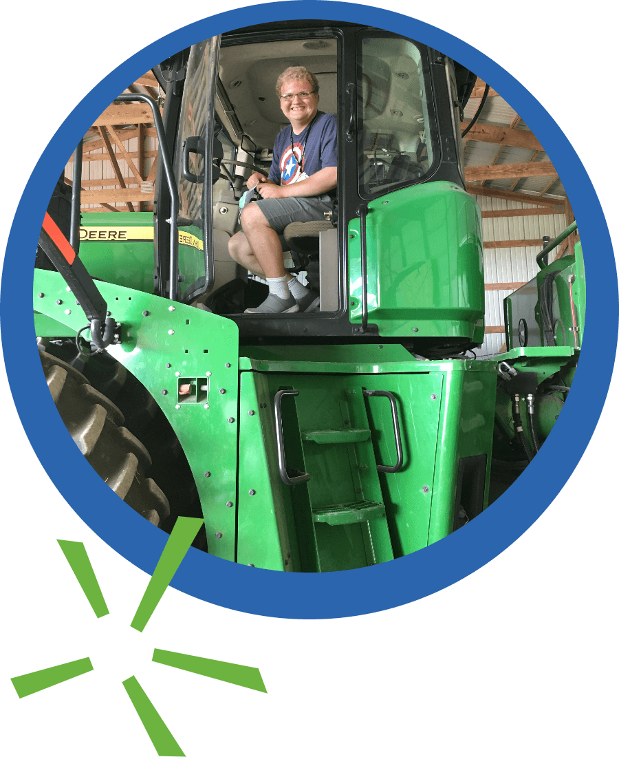 Smiling sitting in the cab of a tractor